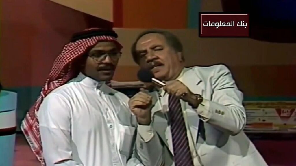 عمر الخطيب على التلفزيون السعودي يقدم بنك المعلومات ومعه رجل يستمع للسؤال